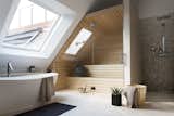 This converted attic in a turn-of-the-century building in Berlin’s Charlottenburg neighborhood has a bathroom skylight that allows residents to enjoy outdoor views during a relaxing soak.
