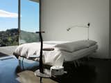 Bedroom, Bed, Wall Lighting, Night Stands, and Concrete Floor  Photo 9 of 12 in Stay in a Minimalist Villa in the Sicilian Countryside, Complete With Sea Views