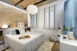 Bedroom, Bed, Dresser, Storage, Pendant Lighting, Medium Hardwood Floor, and Ceramic Tile Floor  Photo 5 of 11 in A Smart Layout Maximizes Space in This Compact Urban Beach Apartment in Barcelona