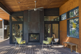 A modern cabin in Washington’s Methow Valley has a fireplace with glazing on two opposite sides, so its owners can watch the embers of the fireplace glowing either while sitting out on the patio, or from the lounge area within.
