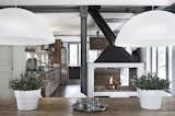 Dining Room, Pendant Lighting, Standard Layout Fireplace, Two-Sided Fireplace, Dark Hardwood Floor, Wood Burning Fireplace, and Table  Photo 4 of 11 in Villa Vergelle by Dwell from Stay in a Modern, Industrial Home That’s Hidden Inside a Traditional Tuscan Villa