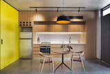Kitchen, Wood Cabinet, Ceramic Tile Backsplashe, Pendant Lighting, Refrigerator, Wall Oven, Concrete Floor, Drop In Sink, and Cooktops  Photo 9 of 25 in 1 by Vaznelis Lukas from What Looks Like a Single Dwelling in Melbourne Actually Holds Six Walk-Up Apartments