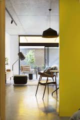 Living Room, Chair, Ottomans, Table, Lamps, Pendant Lighting, Concrete Floor, and Floor Lighting  Photo 13 of 14 in Coppin Street Apartments by Dwell from What Looks Like a Single Dwelling in Melbourne Actually Holds Six Walk-Up Apartments