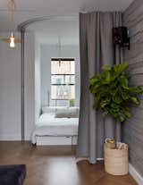 Bedroom, Medium Hardwood Floor, Bed, and Pendant Lighting Small space champion Graham Hill’s 350-square-foot apartment has an office that flips into a sleeping corner with seating cubes that can be arranged to form a bed and a curved Hufcor accordion door.  Photos from 11 Hidden Beds in Small Homes