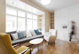 Living Room, Coffee Tables, Storage, Chair, Sofa, Shelves, Medium Hardwood Floor, and Pendant Lighting  Photo 3 of 13 in A Family Apartment in Prague That’s Filled With Clever Storage Solutions and Built-In Nooks