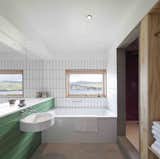 Bath Room, Ceramic Tile Wall, Alcove Tub, Concrete Floor, Ceiling Lighting, and Corner Shower  Photos from Stay in a Modern Tin Cottage on Scotland’s Isle of Skye