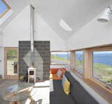Living Room, Coffee Tables, Wall Lighting, Sofa, Wood Burning Fireplace, and Concrete Floor  Photo 14 of 17 in House by Justin from Stay in a Modern Tin Cottage on Scotland’s Isle of Skye