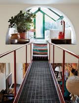 The late Italian designer-architect Gae Aulenti’s home in Milan has a catwalk that begins in the living room and leads up to a solarium sitting area.