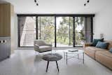 Living Room, Sofa, Coffee Tables, Chair, Ottomans, Rug Floor, and Ceiling Lighting  Photo 10 of 17 in A Remodel Turns a Dark and Choppy House in Melbourne Into a Bright, Flexible Family Home
