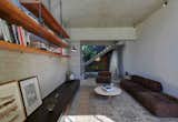 Living Room, Sofa, Chair, Coffee Tables, Shelves, Ceiling Lighting, Concrete Floor, Rug Floor, and Storage  Photo 9 of 17 in Find Out How Light and Precious Outdoor Space Were Introduced to an Old Australian Cottage