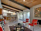 Also designed by William Krisel, this restored midcentury modern built by the Alexander Construction Co. in 1959 has vaulted tongue and groove ceilings and porcelain tile floors, and is furnished with classic designers from Warren Platner, George Nelson and the Eames, as well as vintage midcentury abstract paintings.