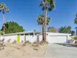This vacation home in the Racquet Club North neighborhood has an eye-catching citrus-hued front door and a living area that makes the most of the Californian sunshine with a wall of glass.  Photo 1 of 13 in 8 Midcentury-Modern Vacation Homes You Can Rent in Palm Springs