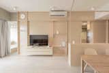 A multifunctional plywood-and-wood veneer wall defines the living area of a simple yet elegant Hong Kong apartment.&nbsp;