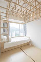 Following the influential saying adopted by Ludwig Mies van der Rohe, "less is more," this Hong Kong apartment taps into the principles of origami by using highly structured and angular plywood features to make a simple yet elegant design statement. Designed by Hong Kong-based practice MNB Design Studio, the living area of this 780-square-foot apartment has a large, multifunctional plywood-and-wood veneer wall that's linked to two sliding doors—one that opens to a storage room and another that opens to the kitchen.