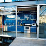 If you're a minimalist, you may prefer hingeless track doors over swinging doors with handles. In this steel-frame Texas home, the bright blue galley-style kitchen has no visible hinges, which makes it look like it's one with the similar-colored back wall.