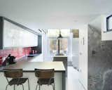 Kitchen, White Cabinet, Ceramic Tile Floor, Ceiling Lighting, Recessed Lighting, Range, Drop In Sink, Subway Tile Backsplashe, Pendant Lighting, and Concrete Counter  Photos from An Old Grain Warehouse on the River Thames Is Transformed Into an Industrial-Modern Home
