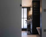Bath Room, Ceramic Tile Floor, One Piece Toilet, Pedestal Sink, Ceramic Tile Wall, and Wall Lighting  Photo 1 of 90 in Bathrooms by Ian Sessions from An Old Grain Warehouse on the River Thames Is Transformed Into an Industrial-Modern Home