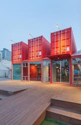 Bold, red-colored shipping containers were used to create a (12 meter long) visitor area extension for the National Theatres Company of Korea. Designed as a social zone for theatregoers, the space was equipped with internal sliding partition walls that can be opened or closed to allow for flexible use of the interior spaces.
