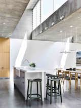 Dining, Bar, Stools, Accent, Concrete, Chair, Table, and Storage  Dining Chair Bar Concrete Storage Photos from Vaulted Skylights and Concrete Columns Connect This Melbourne Home With the Sun