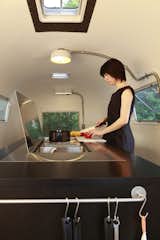 Kitchen, Drop In Sink, and Ceiling Lighting Designed with a series of foldaway furniture, Japanese architect Toshihiko Suzuki transformed a standard trailer into a home with a hidden kitchen, and a dining table for six that doubles up at night as a bed.  Photo 4 of 13 in 6 Modern Homes on Wheels