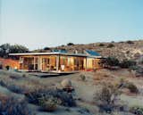 Exterior, Flat RoofLine, Glass Siding Material, Green Roof Material, and Prefab Building Type Los Angeles–based design partners Taalman and Koch created this house in Pioneertown, California from prefabricated structural components, and included glass walls on which artists later applied surface graphics. Available for rent through Boutique Homes, this 1,100-square-foot house cost approximately $265,000 to build and is composed of a Bosch aluminum framing system and perforated steel decking roof. The interiors floor are equipped with radiant heating and cabinets were built out of Formica or plastic-laminated plywood.  Photo 66 of 66 in The Ultimate Guide to Prefab: 65 Resources by Location, Construction, and Price from 7 Incredible Prefab Homes You Can Rent For Your Next Holiday