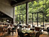 Dining Room, Table, Chair, Floor Lighting, Recessed Lighting, and Medium Hardwood Floor "Alila Yangshuo is located on a natural site, so I had the opportunity to think of how the environment can impact and influence the architecture and its function," says Dong.   Photo 17 of 18 in A Chinese Sugar Mill From the 1960s Becomes a Cave-Inspired Hotel