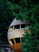 Located in the woods of Malborghetto Valbruna in the Italian Dolomite commune of Tarvisio, this egg-shaped tree house appears to hover in midair like a giant pinecone.