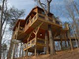 Located in the Aska Adventure area of Blue Ridge, Georgia, this 750-square-foot, three-story tree house called "Canopy Blue" has close to 1,200 square feet of outdoor deck and is great for families with kids. The house has high ceilings, French doors that overlook a fire pit below, a table crafted from a hollowed tree trunk, bunk beds, and a loft with a swing bed.