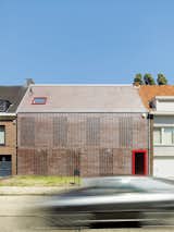 To provide maximum privacy and natural light penetration, Belgium-based DMVA Architects created a frontage composed of "knitted" bricks, which brings light and air into the home.