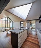 Kitchen, Concrete Counter, Dishwasher, Undermount Sink, Pendant Lighting, and Medium Hardwood Floor  Photos from A New Hip Roof Rejuvenates a California-Style Bungalow in Melbourne