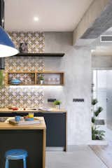 A backsplash with gray, mustard, and white hydraulic-imitation tiles from Portuguese brand Recer gives this Barcelona apartment plenty of dynamic and graphic charm.