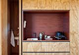 In this kitchen alcove in a New Zealand cabin, oiled jarrah eucalyptus contrasts with a kitchen niche made of plywood that's been stained reddish-brown.&nbsp;