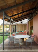 Outdoor, Back Yard, Grass, Small Patio, Porch, Deck, Wood Patio, Porch, Deck, Decking Patio, Porch, Deck, and Hanging Lighting  Photo 1 of 116 in Modern Fan Co. on Dwell by The Modern Fan Company from An Incredible Home in Hawaii That’s As Much Fun As Summer Camp