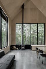 This voluminous cabin in Austin, Quebec, has a sharply pitched roof and a bright and lofty interior that strikes surprising contrast to its austere, angular exterior.