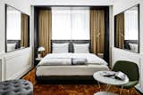 Bedroom, Chair, Bed, Lamps, Table Lighting, Rug Floor, and Wall Lighting Mirrors are used to visually enlarge some of the smaller rooms.  Photo 9 of 15 in This Munich Hotel Looks Like It's From a James Bond Movie