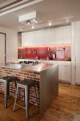Bunker Workshop used bright, red steel pegboard for the backsplash in this kitchen in Boston loft apartment in a former textile factory.&nbsp;