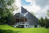 Pioneer of the design-build movement, David Sellers Pyramid House on Prickly Mountain, Vermont cuts a striking silhouette with a sharply angled roof, and a raised terrace in the front of the house.