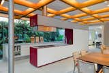 Kitchen, Recessed Lighting, Colorful Cabinet, Concrete Floor, Range, Drop In Sink, White Cabinet, and Range Hood  Photos from This Brilliant Brazilian Abode Was Designed Around an Imposing Tree