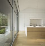 The white kitchen appears as if it were an extension of the walls and ceilings.