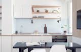 Kitchen, Laminate, Track, White, Drop In, Wall Oven, Open, and Cooktops A small kitchenette and dining room is located the the windows.  Kitchen White Wall Oven Open Cooktops Photos from A Tiny Apartment in the Italian Riviera Takes Cues From Nautical Design