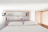 Bedroom, Shelves, Wall Lighting, and Bed The cabin-like bedroom contains a king-sized bed and minimalist built-in shelves.  Photo 5 of 9 in A Tiny Apartment in the Italian Riviera Takes Cues From Nautical Design