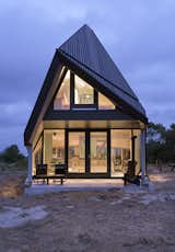 Exterior, House Building Type, and Glass Siding Material A covered porch on the ground floor.  Photo 4 of 11 in A Tent-Shaped Home in the Netherlands Crouches Between Natural Dunes