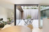 Outdoor, Shrubs, Wood Patio, Porch, Deck, Wood Fences, Wall, Vertical Fences, Wall, Small Patio, Porch, Deck, and Hardscapes The courtyard allows light to penetrate deep into the room.  Photo 3 of 14 in A Belgian Architect’s Courtyard House Offers Work/Life Balance