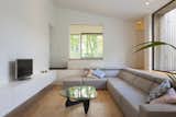 Living Room, Sectional, Recessed Lighting, Coffee Tables, Light Hardwood Floor, and Storage A Noguchi coffee table in the living lounge.  Photo 6 of 14 in A Belgian Architect’s Courtyard House Offers Work/Life Balance