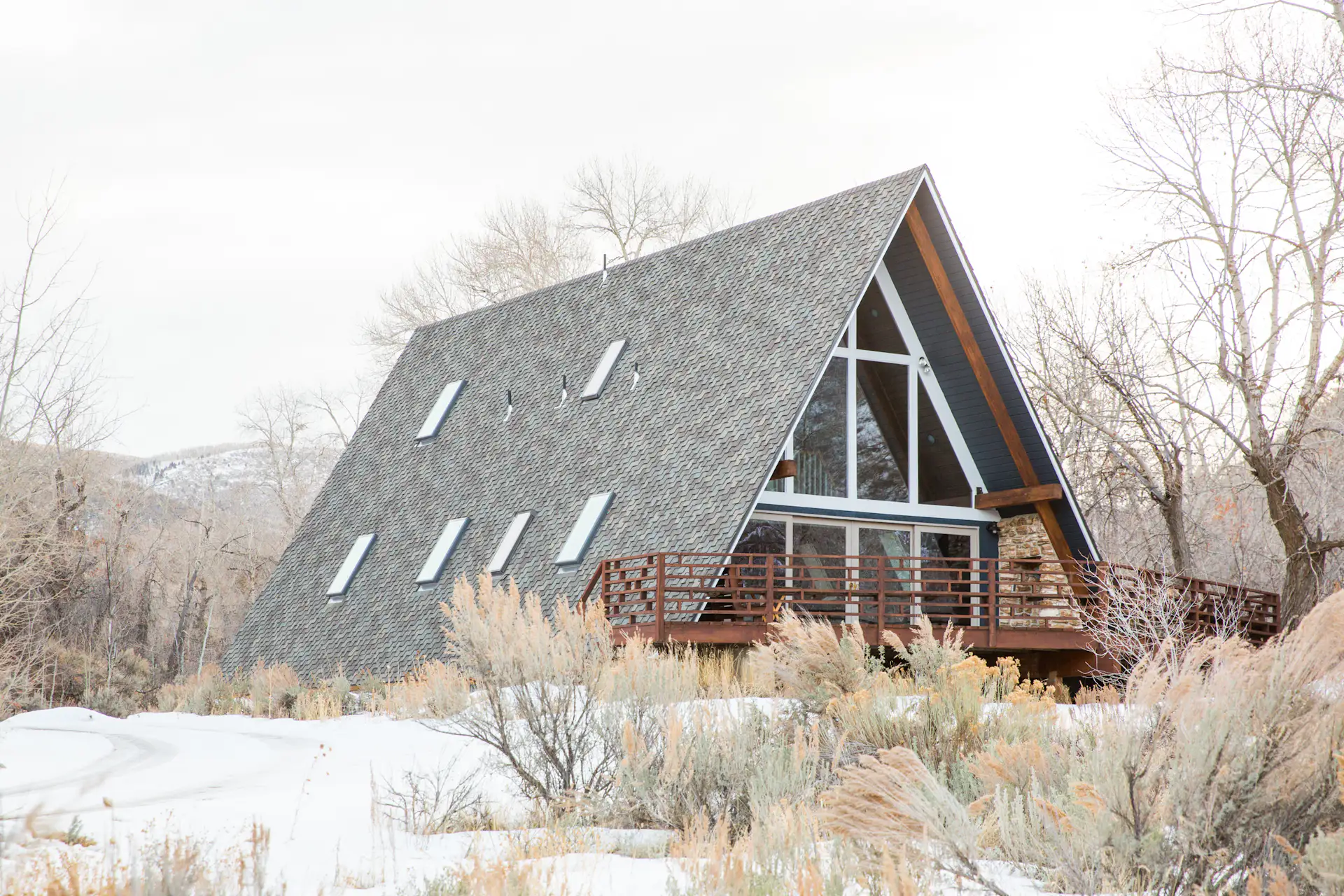 A-Frame Haus in Herber City, Utah, is fully remodeled with Scandinavian-inspired interiors. The large spans of glazing provide panoramic views of surrounding mountains, greenery, and all that Utah has to offer.