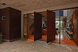 Doors, Swing, Interior, Metal, and Exterior Four, pivoting Corten-steel doors help with cross ventilation.  Doors Exterior Interior Photos from This Slender Concrete Home in Brazil Feels Like an Urban Jungle