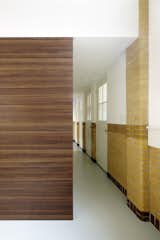 A wooden box, which houses a walk-in closet and stairs to the bedrooms, acts as a partition that dissects the hallway.