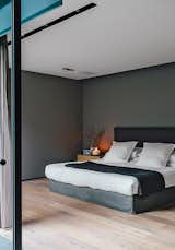 Bedroom, Ceiling Lighting, Bed, Night Stands, Medium Hardwood Floor, and Recessed Lighting The master bedroom, painted in Whisper by Comex, sports a bed that Farca custom-designed as part of his EF Collection.  Photo 5 of 6 in 5 Design Tips for a Better Night’s Sleep