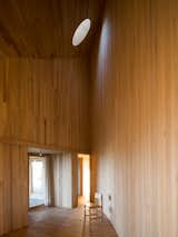 A circular skylight illuminates the minimal, timber-clad living areas inside the dramatic Rode House on Chiloé Island. The 2,000-square-foot, semicircular home was designed by Mauricio Pezo and Sofia von Ellrichshausen of Chilean practice Pezo von Ellrichshausen.&nbsp; &nbsp;