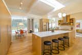Kitchen, Quartzite, Wood, Pendant, Medium Hardwood, Track, Range, Open, Refrigerator, and Range Hood The remodelled kitchen.  Kitchen Medium Hardwood Pendant Refrigerator Open Photos from A Meticulously Updated Midcentury in L.A. Asks $1.49M